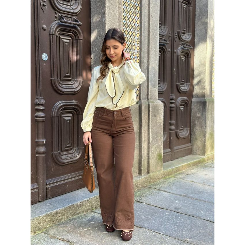 Calças castanhas com bordados na baínha