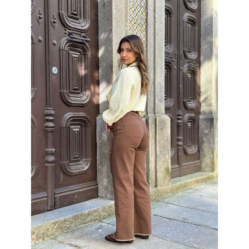 Calças castanhas com bordados na baínha