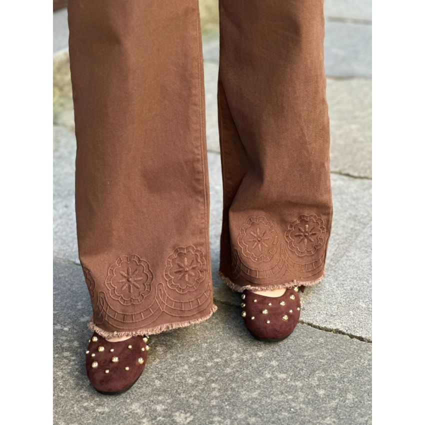 Calças castanhas com bordados na baínha